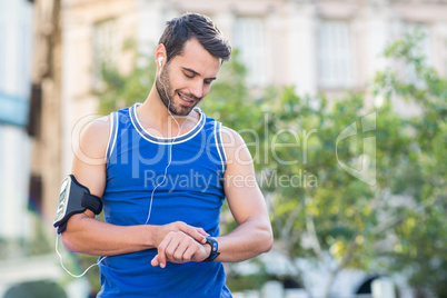 An handsome athlete looking at the time