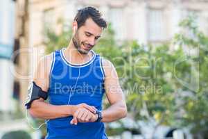 An handsome athlete looking at the time