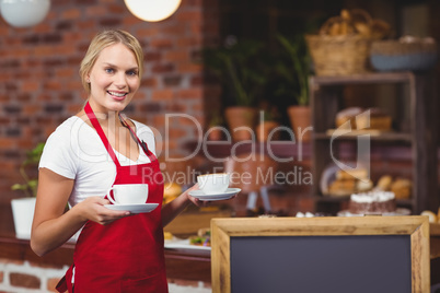 Pretty waitress holding two cups of coffees