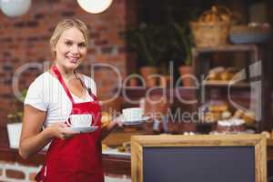 Pretty waitress holding two cups of coffees