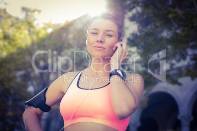 A beautiful athlete putting her headphones