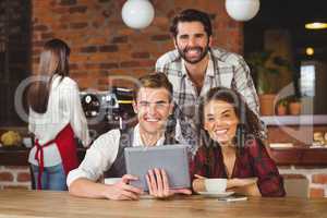 Smiling friends holding a digital tablet