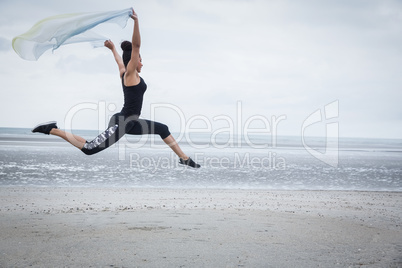 Fit girl leaping with scarf