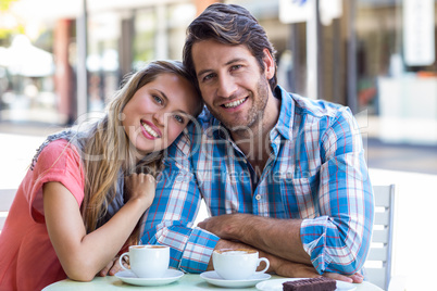 Smiling couple having tea in a cafe