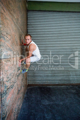 Extreme athlete gripping to wall
