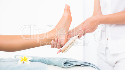 Side view of a young woman receiving pedicure treatment