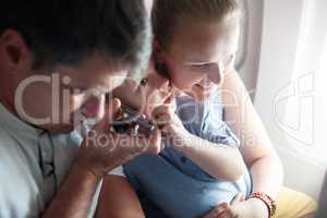 Parents and child listening something on the cell