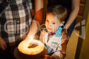 Little boy carrying birthday cake