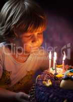Little boy blows out candles on his birthday
