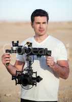 Videographer with steadicam equipment on the beach