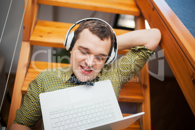 Man entertaining with laptop and music at home
