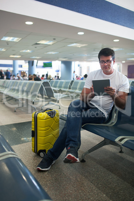 Young man using touch pad in the airport lounge