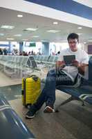 Young man using touch pad in the airport lounge