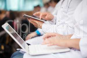 Medical students with pad and laptops in auditorium