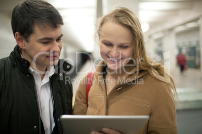 Young couple using tablet computer in underground