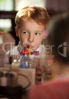 Little boy drinking with tubule
