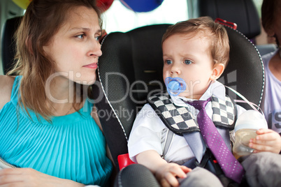 Mom looking at her son in child safety seat