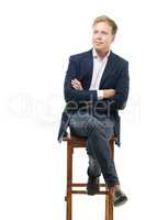 Young businessman sitting on high wooden chair