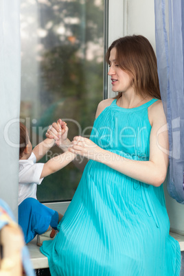 Pregnant woman plays with little boy