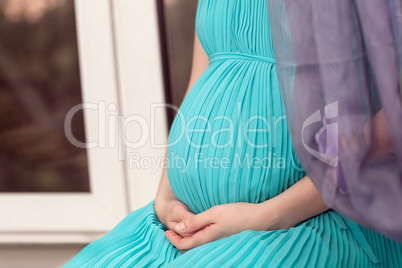 Pregnant woman on the window sill