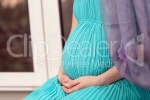 Pregnant woman on the window sill