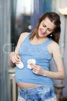 Happy pregnant woman with white baby booties