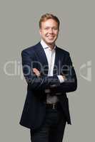 Cheerful businessman with crossed arms isolated on grey