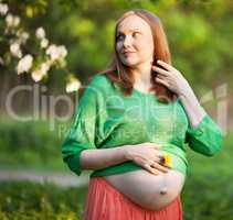 Pregnant woman in the light of evening sun outdoor