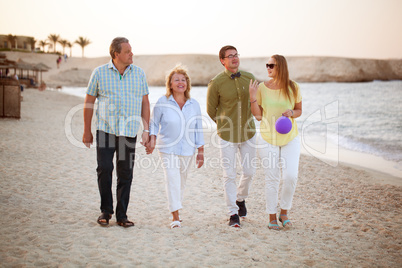 Young and senior couples walking along the coast