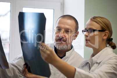 Senior and young doctors examining x-ray images