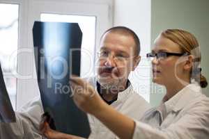 Senior and young doctors examining x-ray images