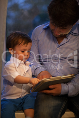 Man and little boy playing with tablet