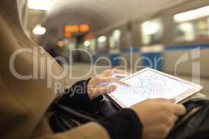 Tablet in female hands showing subway map in underground