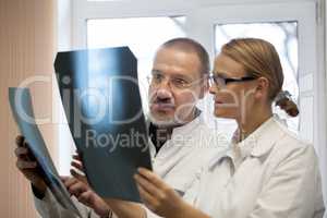 Professor and young doctor comparing x-rays