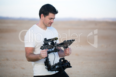 Young man using steadycam for shooting on beach