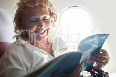 Mature Woman Reading Magazine on a Plane