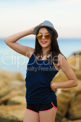 Young smiling girl in grey hat and sun glasses