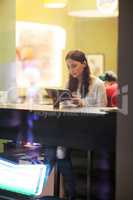 Young brunette girl using tablet in the cafe