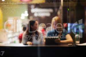 Two female friends using tablet PC in a cafe