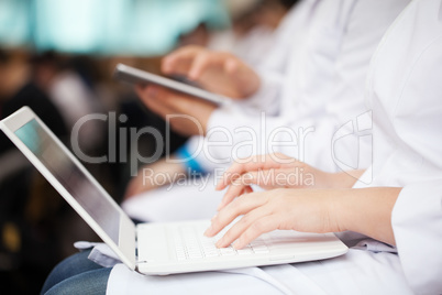 Doctors with laptop and pad on the conference