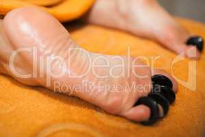 Woman getting hot stone massage on feet