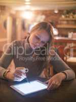 Woman with Tablet PC and Stylus in Cafe