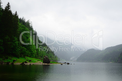 riesiger felsen am see