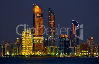 Skyline von Abu Dhabi im Abendlicht mit Wasser im Vordergrund