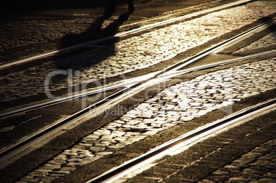 Schienen Gleise in der Abendsonne mit Schatten einer Person