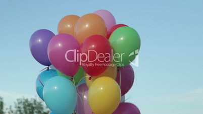 Hand holding multicolored balloons