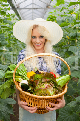 Attraktive blonde Frau mit einem Korb voller Gemüse