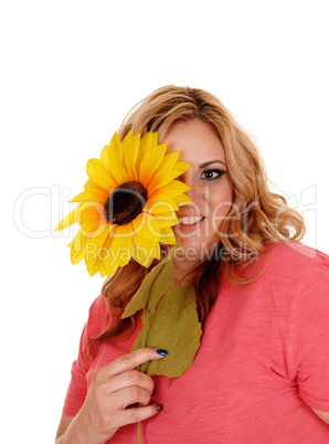 Woman holding sunflower for one eye.