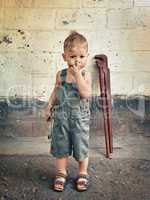 little boy with a wrench standing at the wall