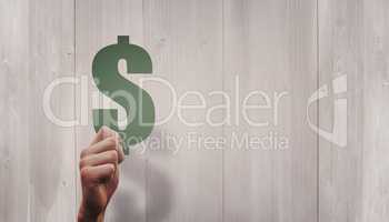 Composite image of hand holding dollar sign